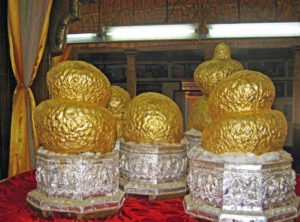Fünf über und über mit Gold beklebte Buddha-Figuren am Inle-See